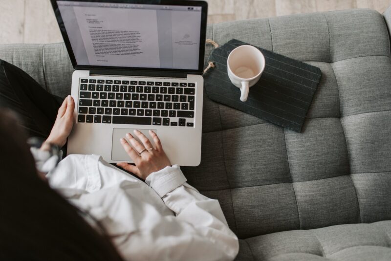 Woman typing on keyboard of laptop