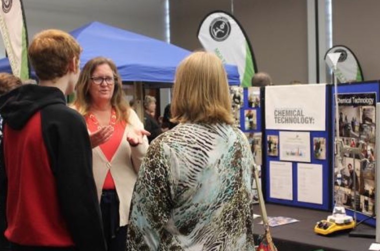 Faculty member talks to visitors at ENGAGE 2019