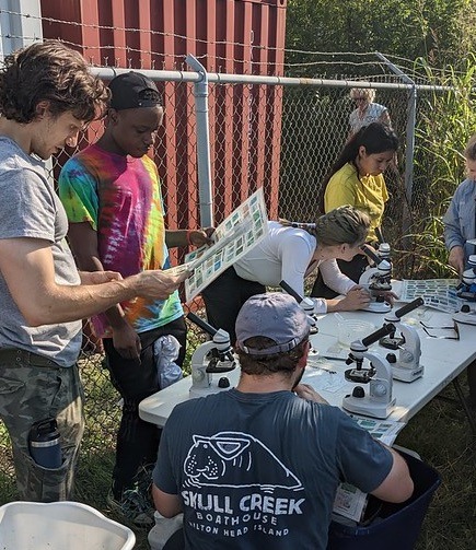 Students using microscopes to examine samples