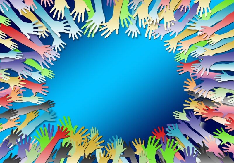 circle of multicolored hands on blue background