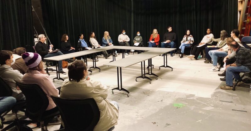 Photo of student scriptwriters and professional actors gathered for table read
