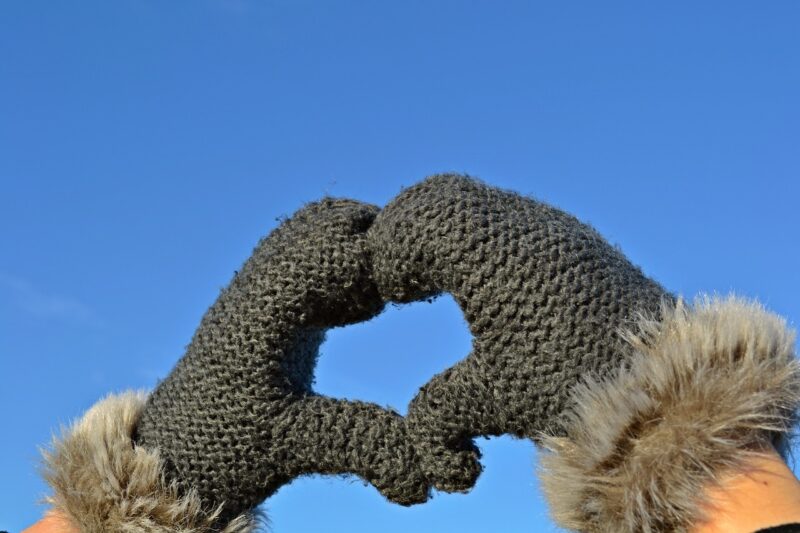 hands in gloves forming heart symbol