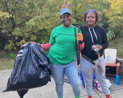 Students with garbage bags and debris removal tools