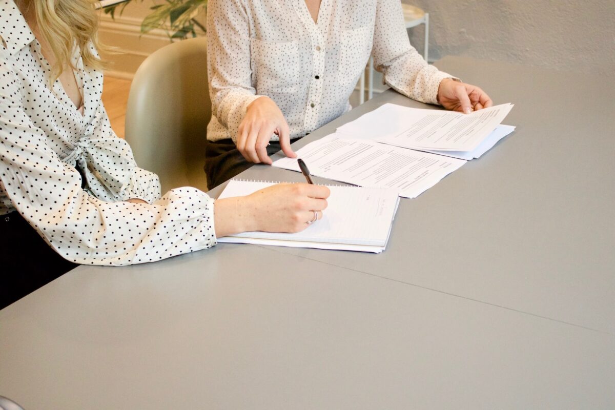 two women reviewing documents on a table