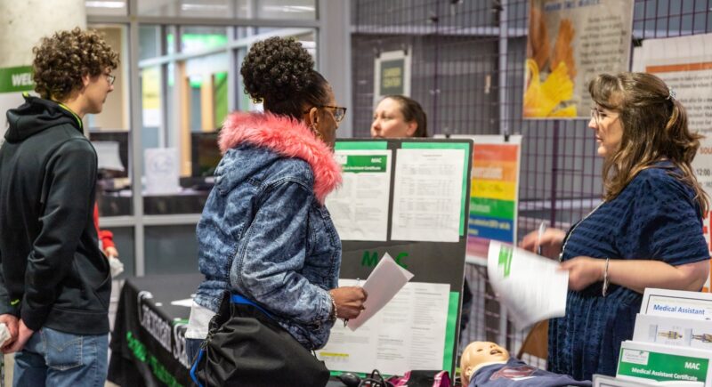 Faculty members greeting students at Spring Open House