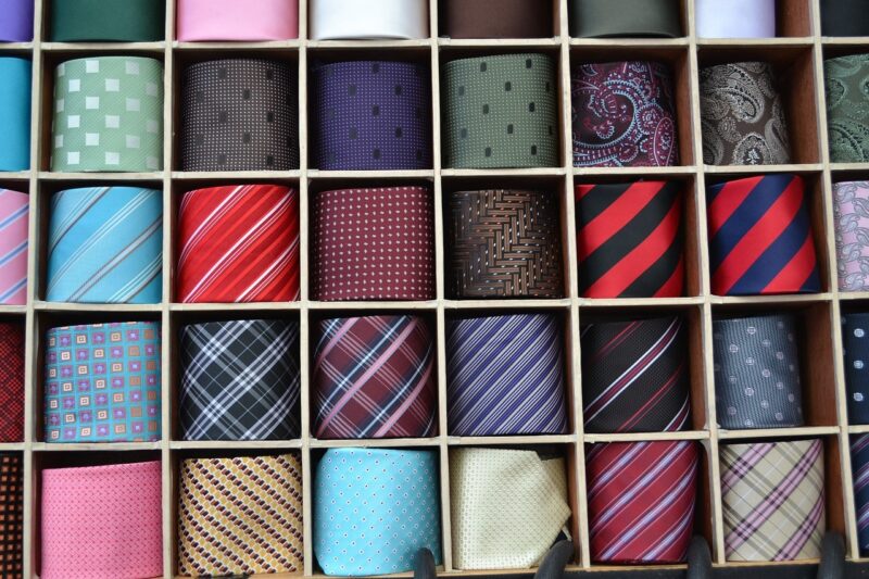 variety of men's ties in a container with each tie in a separate square