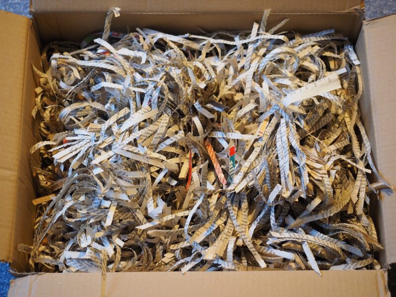 multi-color shredded paper in a brown box