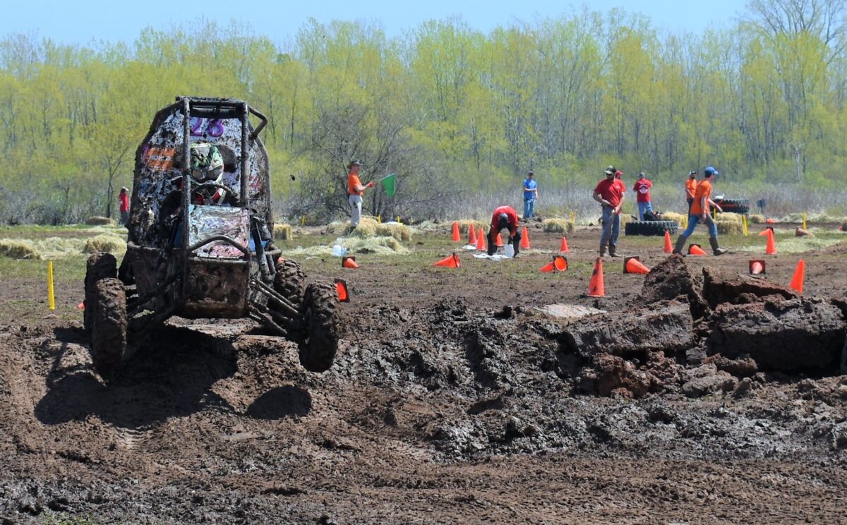 Cincy Baja car jumping over a muddy hazard