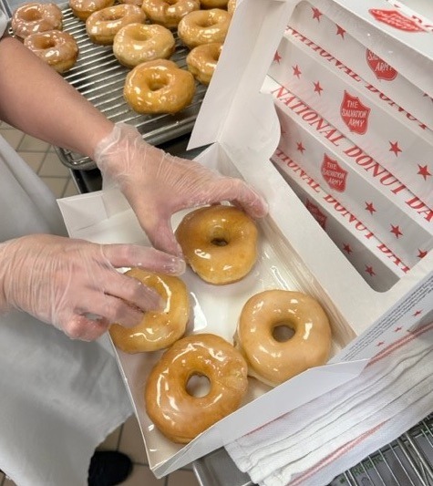 Student packing box of finished donuts