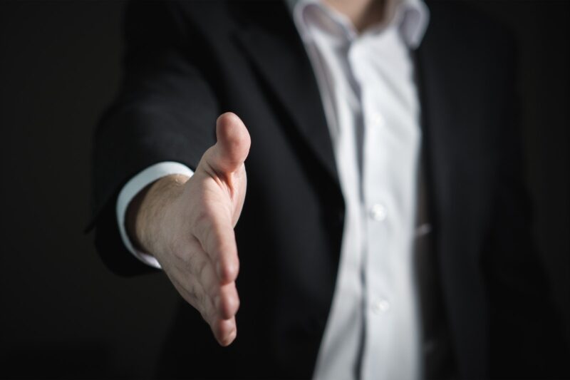 Close-up of hand reaching out to shake hands