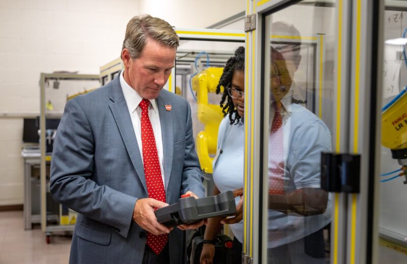 Zemirah Torrey shows Lt. Gov. Jon Husted how to operate an industrial robot in a CState lab
