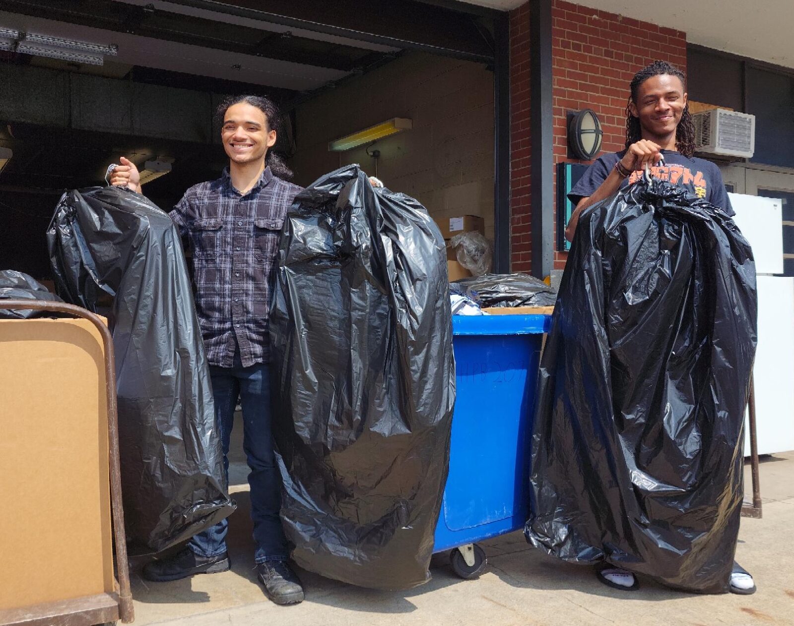 Students Tristan and Jamal moved donated items into the Career Closet