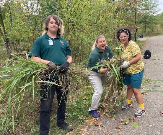 Three students picking up debris