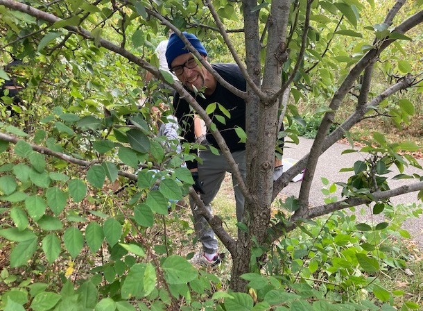 Student smiling while climbing a tree