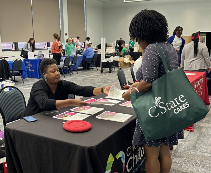 Student talks to representative from Cincinnati Children's Hospital at the Health & Wellness Fair 2023