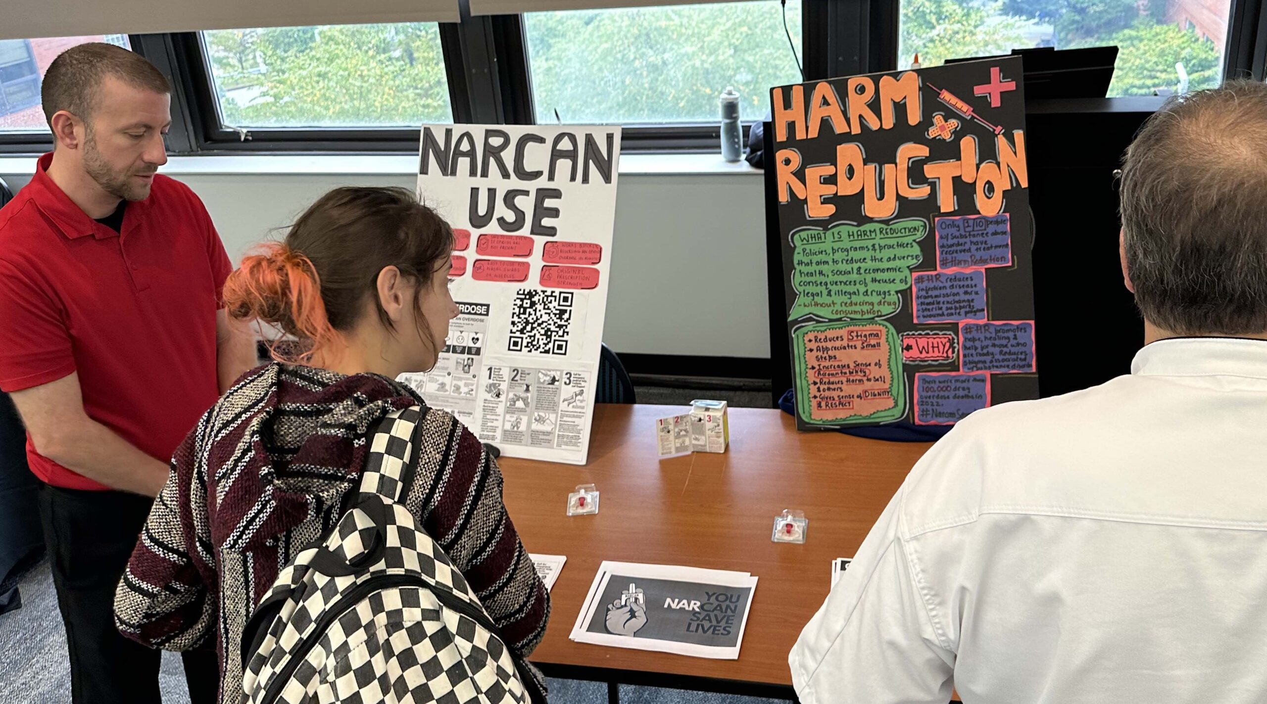 Students viewing posters about using Narcan to treat drug overdose