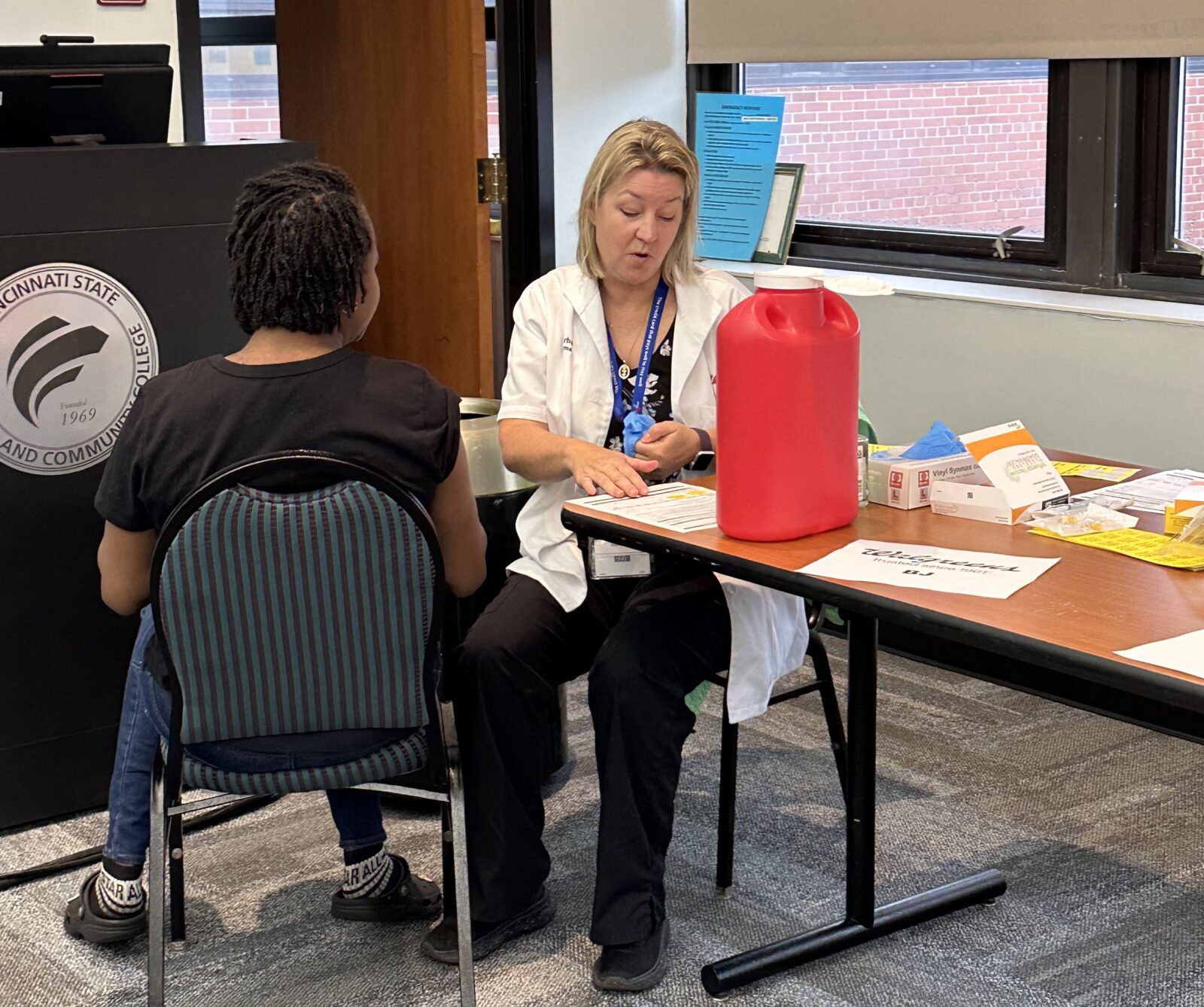 Walgreens technician prepares to give a student a flu shot