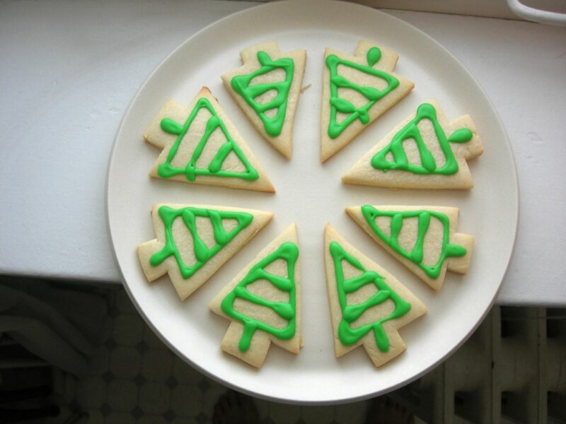 white plate with 8 cookies in the shape of trees forming a circle on the plate