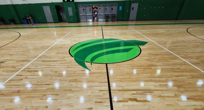 Refinished basketball court in the Clifton Campus gym with Cincinnati State logo in the center of the floor