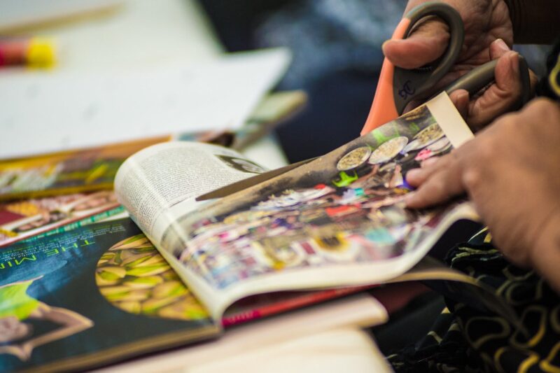 hands with scissors cutting a picture from a magazine