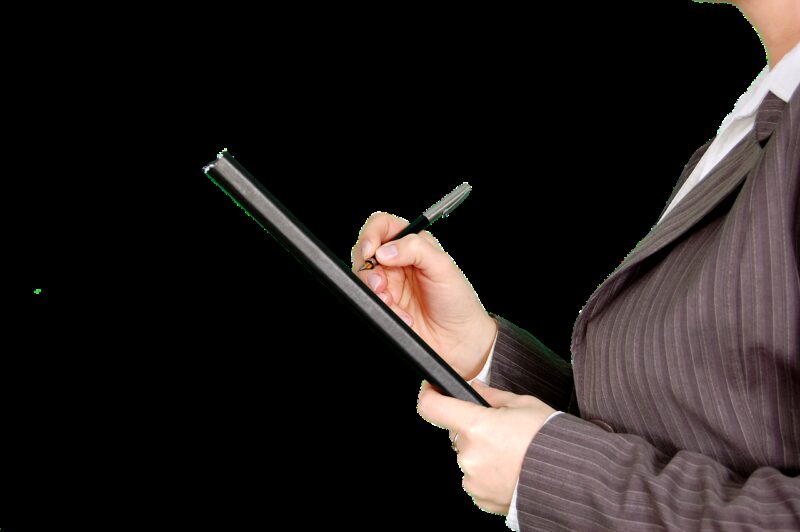 hands of person wearing a business suit, filling out a paper form with a pen