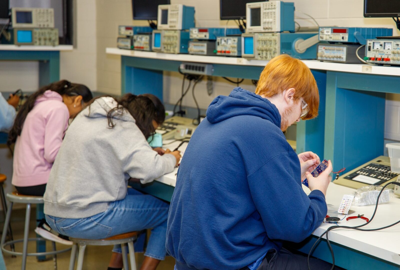 Three students concentrating on their lab activity during Career Tech Expo