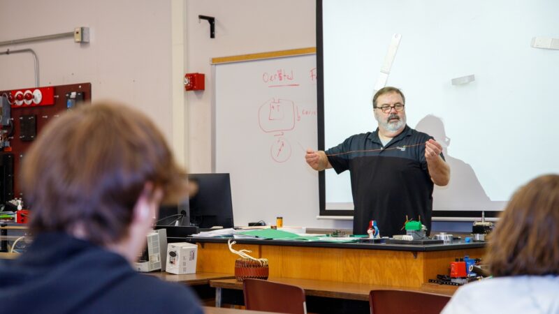 Prof Larry Feist helps students build a simple motor - CareerTech Expo