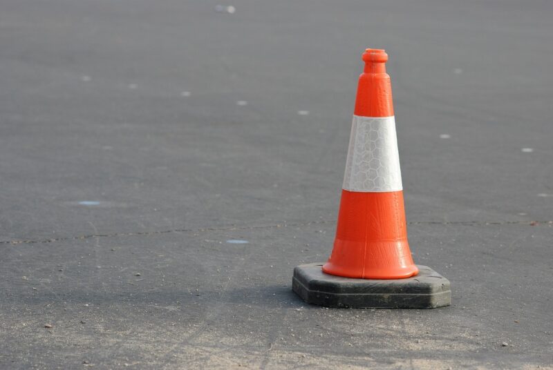 orange construction cone on gray pavement