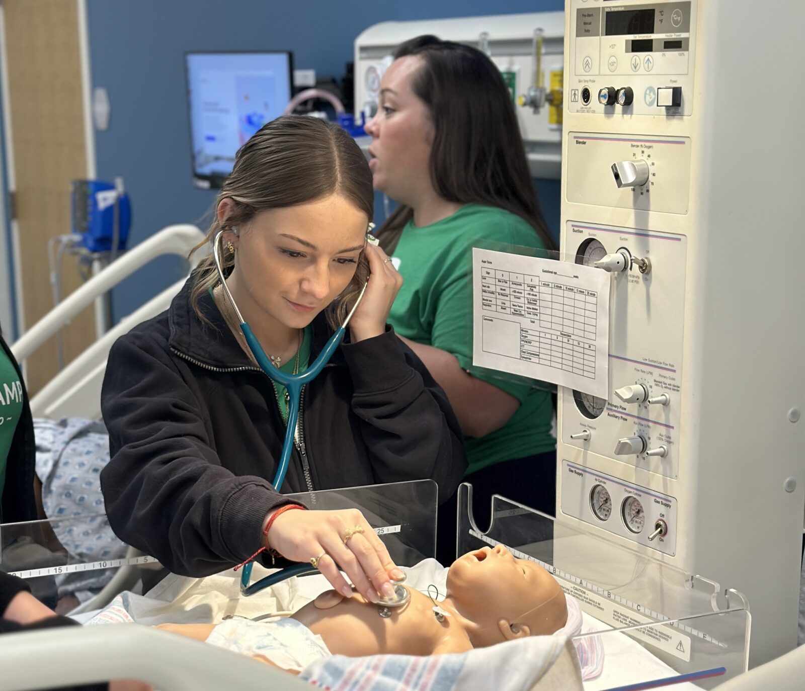 Student examines an infant patient at Scrubs Camp 2025