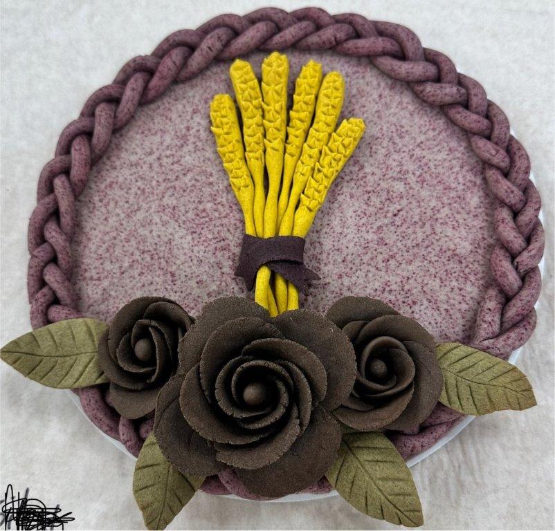 "Dead dough" sculpture - black flowers, green leaves, yellow stalks of wheat, purple braided border