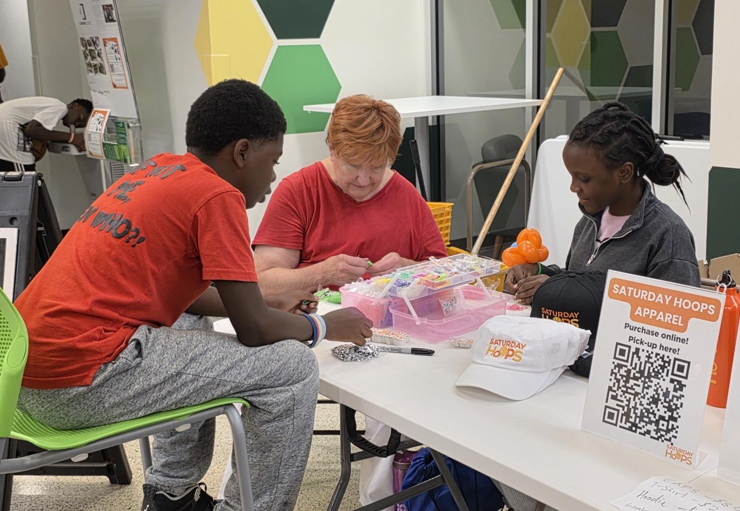 Students and volunteers working with beads at CYC Back to School event