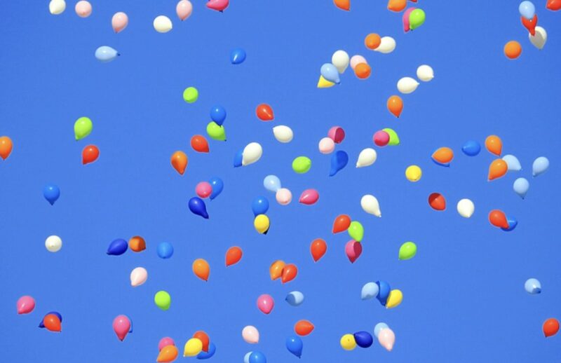 multicolored balloons floating on a blue sky