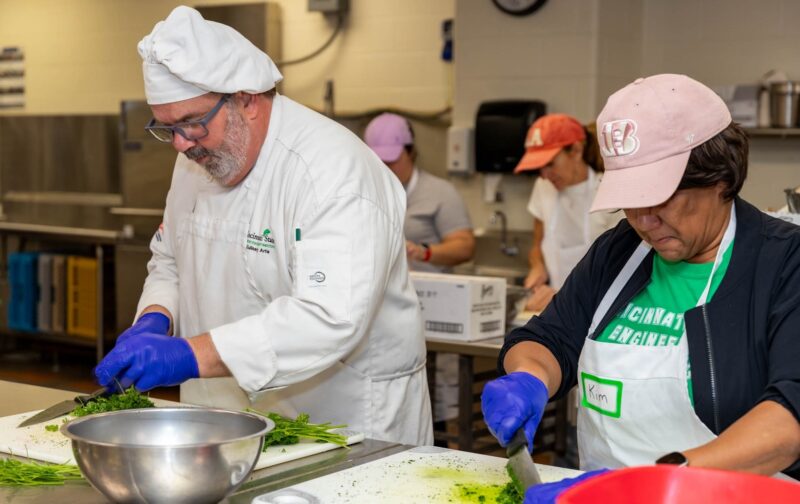 Students and employees working together making soup