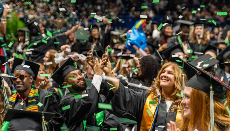 Graduates celebrating while confetti falls at the end of Commencement 2026