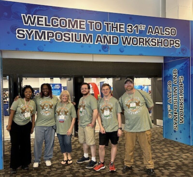 EVT students and faculty in front of the event welcome sign at the 2026 AALSO Conference